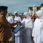 Pj Bupati Aceh Utara Serahkan Penghargaan untuk Nakes Teladan dan Gampong Berprestasi usai Pimpin Apel Gabungan